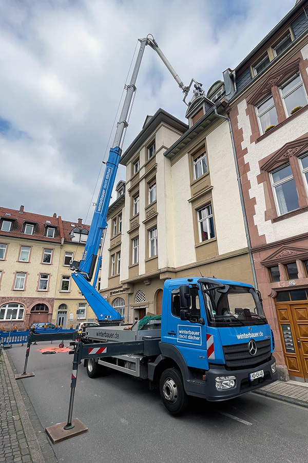 Autokran in Aktion vor einem Haus